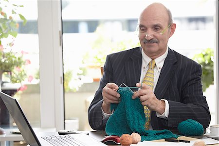 Businessman knitting at desk Stock Photo - Premium Royalty-Free, Code: 649-06717634