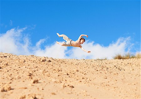 shirtless, boy - Boy jumping on beach Stock Photo - Premium Royalty-Free, Code: 649-06812028