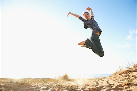 simsearch:649-06812058,k - Teenage girl jumping on beach Fotografie stock - Premium Royalty-Free, Codice: 649-06812039