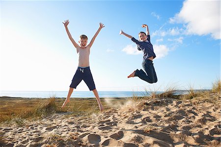 simsearch:649-06812033,k - Boy and teenage girl jumping on beach Stock Photo - Premium Royalty-Free, Code: 649-06812049