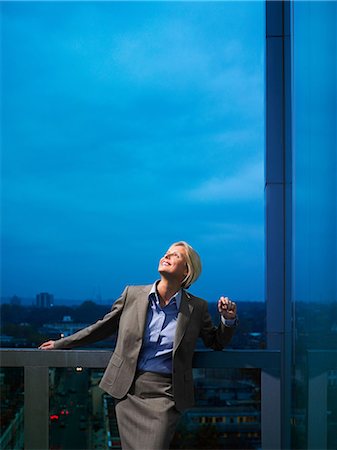 smiling blond woman in business suit - Smart lady in corporate environment overlooking the city Foto de stock - Sin royalties Premium, Código: 649-06812087