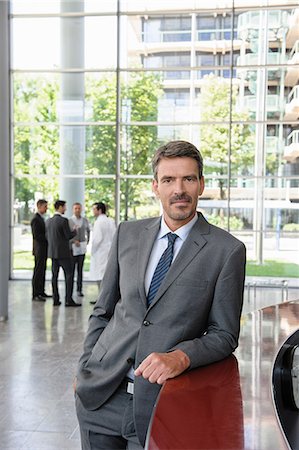 reception business - Businessman leaning against reception desk Stock Photo - Premium Royalty-Free, Code: 649-06812105