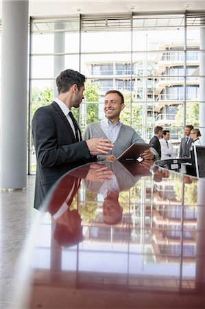 simsearch:649-06812108,k - Two men in discussion at reception desk Foto de stock - Sin royalties Premium, Código: 649-06812107