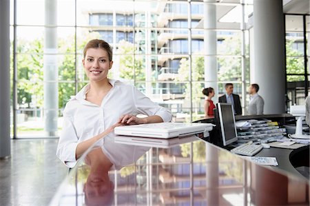 Business woman leaning against reception desk Stock Photo - Premium Royalty-Free, Code: 649-06812115