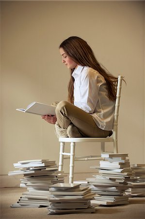 Girl sitting on chair reading book Photographie de stock - Premium Libres de Droits, Code: 649-06812230