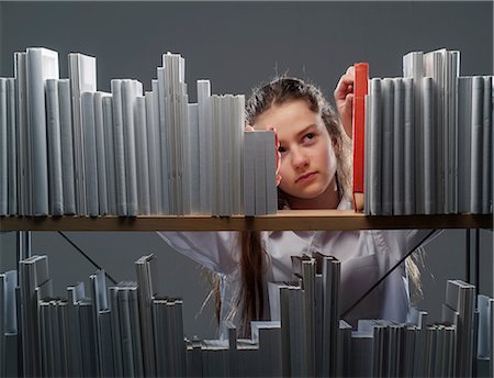 selecting - Girl choosing red book from bookshelf Foto de stock - Sin royalties Premium, Código: 649-06812245