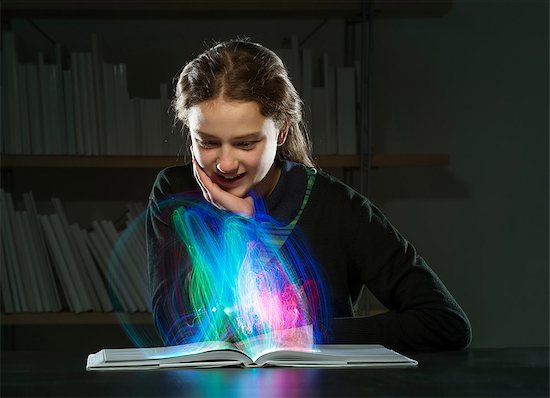 Girl reading book with multicoloured lights Stock Photo - Premium Royalty-Free, Image code: 649-06812247