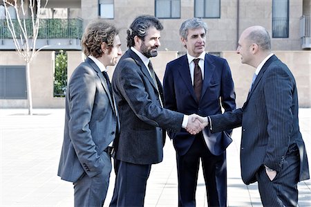Businessmen shaking hands outdoors Stock Photo - Premium Royalty-Free, Code: 649-06812271