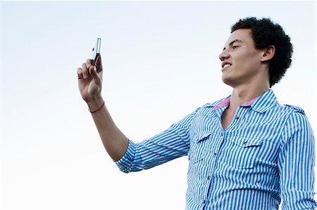 Young man taking a picture of himself Stock Photo - Premium Royalty-Free, Code: 649-06812361