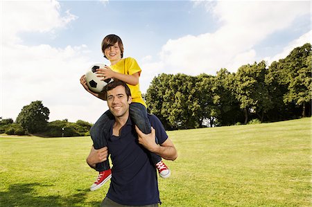 Father carrying son on shoulders with football Photographie de stock - Premium Libres de Droits, Code: 649-06812420
