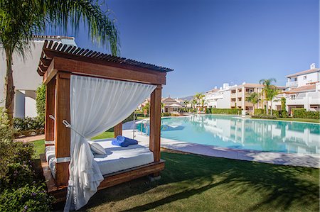 Luxury sun lounger by swimming pool at holiday resort Photographie de stock - Premium Libres de Droits, Code: 649-06812466