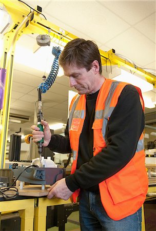 Man working on machinery in electrical component factory Photographie de stock - Premium Libres de Droits, Code: 649-06812499