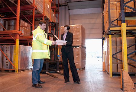 factory worker photography - Man and woman looking at paperwork in warehouse Photographie de stock - Premium Libres de Droits, Code: 649-06812491