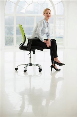 escaso - Businesswoman sitting on office chair in sparse white room Foto de stock - Sin royalties Premium, Código: 649-06812559