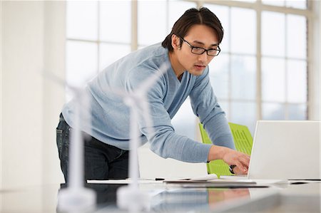 engineer at desk - Man using laptop with models of wind turbines on desk Foto de stock - Sin royalties Premium, Código: 649-06812610