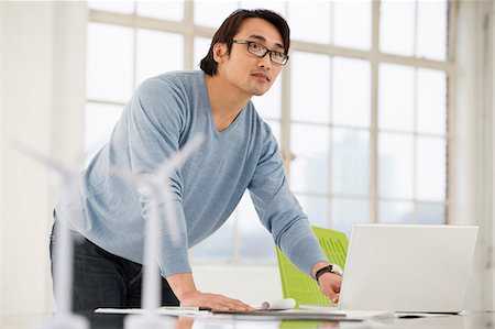 Man using laptop with models of wind turbines on desk Foto de stock - Sin royalties Premium, Código: 649-06812611