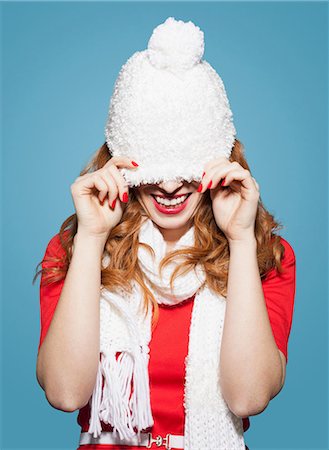 Woman pulling white bobble hat over eyes Stock Photo - Premium Royalty-Free, Code: 649-06812654