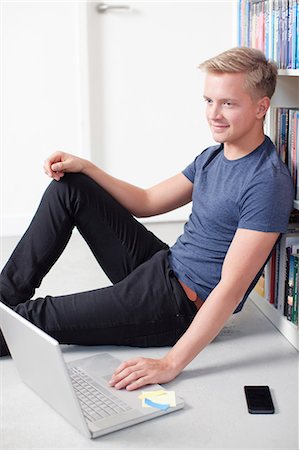 simsearch:649-06812666,k - Young man sitting on floor using laptop Fotografie stock - Premium Royalty-Free, Codice: 649-06812689