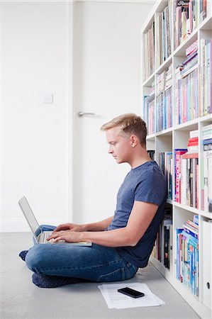 simsearch:649-06812683,k - Young man sitting on floor using laptop Foto de stock - Sin royalties Premium, Código: 649-06812696