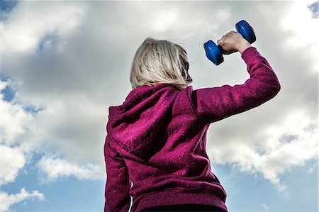 Young woman using hand weights Stock Photo - Premium Royalty-Free, Code: 649-06812777