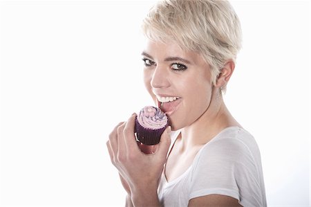 Woman eating cupcake Stock Photo - Premium Royalty-Free, Code: 649-06812771