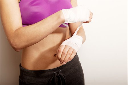 pugilista (mujer) - Young woman wrapping bandage on wrist Foto de stock - Sin royalties Premium, Código: 649-06812856