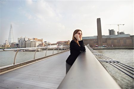 Woman on cell phone on Millennium Bridge, London, England, UK Stock Photo - Premium Royalty-Free, Code: 649-06812889