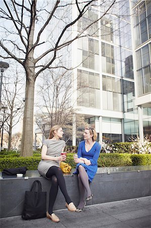 pictures of business women in city - Businesswomen sitting on wall for coffee break Stock Photo - Premium Royalty-Free, Code: 649-06812880