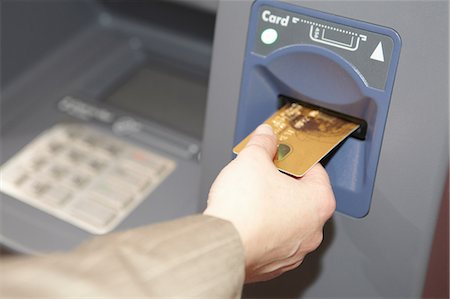 sacar dinero - Woman inserting credit card into cashpoint Foto de stock - Sin royalties Premium, Código: 649-06812926