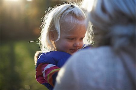 family candid outdoors - Young girl with mother outdoors in sunlight, close up Foto de stock - Sin royalties Premium, Código: 649-06812976