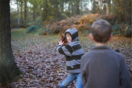 Boy throwing leaves at friend Stock Photo - Premium Royalty-Free, Code: 649-06812987