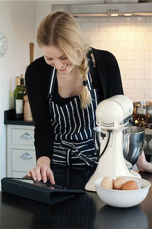 Woman using digital tablet to check recipe Foto de stock - Sin royalties Premium, Código: 649-06813060