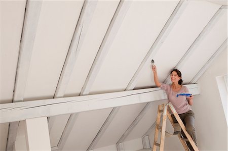 Woman on stepladders painting white ceiling Photographie de stock - Premium Libres de Droits, Code: 649-06829393