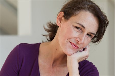 Portrait of woman wearing purple top, hand on chin Stock Photo - Premium Royalty-Free, Code: 649-06829401