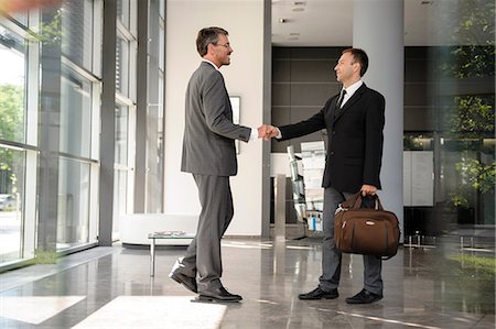 shaking hand business - Businessmen shaking hands in lobby Stock Photo - Premium Royalty-Free, Code: 649-06829460