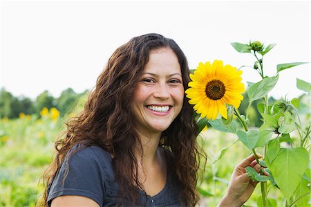 Portrait of young woman with yellow sunflowers in allotment Stock Photo - Premium Royalty-Free, Code: 649-06829470