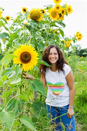 Portrait of young woman with yellow sunflowers in allotment Stockbilder - Premium RF Lizenzfrei, Bildnummer: 649-06829473