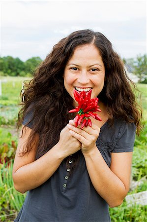 simsearch:649-06829480,k - Portrait of young woman holding  crop of red chillies in allotment Stockbilder - Premium RF Lizenzfrei, Bildnummer: 649-06829487