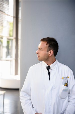 simsearch:649-06829838,k - Mid adult doctor in lab coat looking away Fotografie stock - Premium Royalty-Free, Codice: 649-06829497