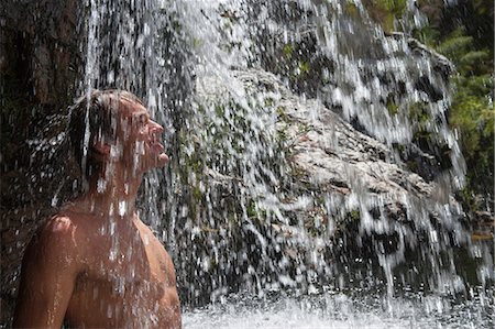 Young man standing under waterfall Photographie de stock - Premium Libres de Droits, Code: 649-06829502