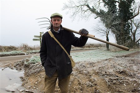 Portrait of mature farmer holding pitchfork Stock Photo - Premium Royalty-Free, Code: 649-06829519