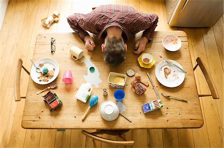 Overhead view of breakfast table with mature man amongst messy plates Stock Photo - Premium Royalty-Free, Code: 649-06829561