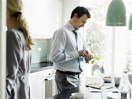 simsearch:649-06829625,k - Mature businessman checking time in kitchen Stock Photo - Premium Royalty-Free, Code: 649-06829614