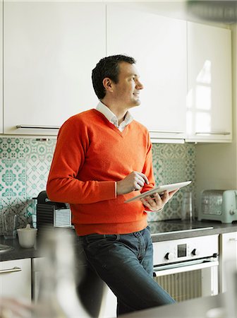 simsearch:649-06829612,k - Mature man using tablet in kitchen Stock Photo - Premium Royalty-Free, Code: 649-06829610