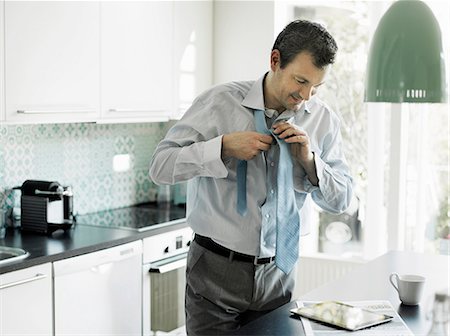 Mature businessman getting ready and using tablet in kitchen Photographie de stock - Premium Libres de Droits, Code: 649-06829613