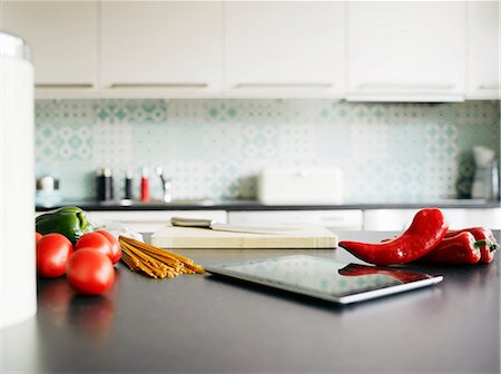 Digital tablet, red peppers and tomatoes on kitchen counter Foto de stock - Sin royalties Premium, Código: 649-06829620