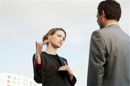 explicando - Mid adult businesswoman speaking to colleague outdoors Foto de stock - Sin royalties Premium, Código: 649-06829640