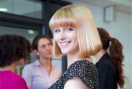 simsearch:649-06829703,k - Portrait of woman with blonde bob and colleagues in background Stock Photo - Premium Royalty-Free, Code: 649-06829686