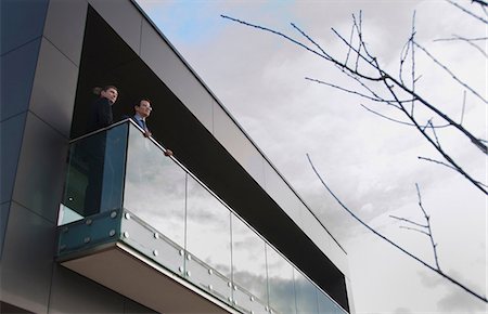 desenvolvimento - Two office colleagues on balcony, low angle Foto de stock - Royalty Free Premium, Número: 649-06829694