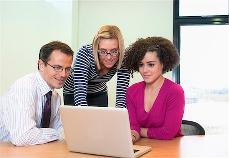 simsearch:649-06829703,k - Three colleagues working on laptop in office Stock Photo - Premium Royalty-Free, Code: 649-06829716